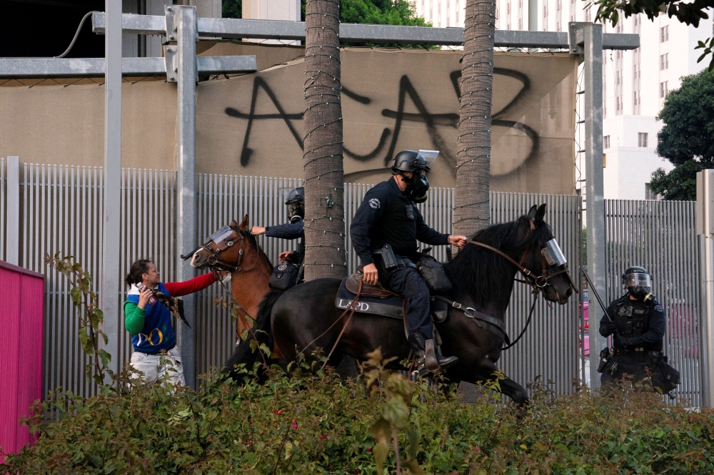 Police clear demonstrators after they block a street with a barricade during a protest against federal immigration sweeps in downtown Los Angeles, California, US June 8, 2025. — Reuters pic