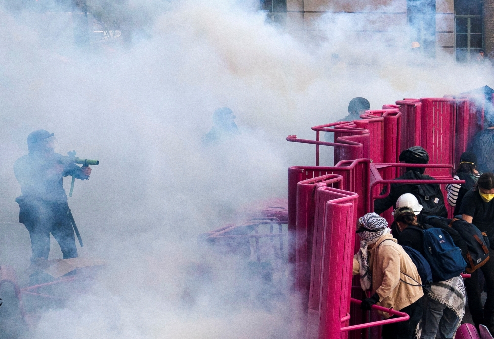 Police clear demonstrators after they blocked a street with a barricade during a protest against federal immigration sweeps in downtown Los Angeles. — Reuters pic