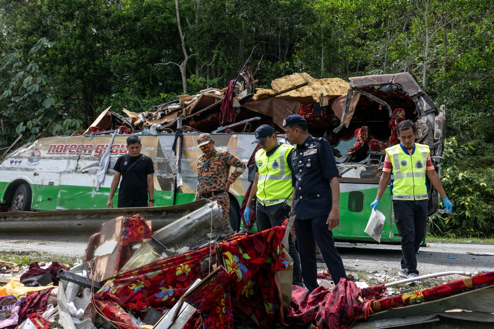 Police personnel search for important documents at the site of the tragic accident that claimed the lives of 15 Universiti Pendidikan Sultan Idris (UPSI) students at KM53 of the East-West Highway (JRTB) near Gerik, June 9, 2025. — Bernama pic 