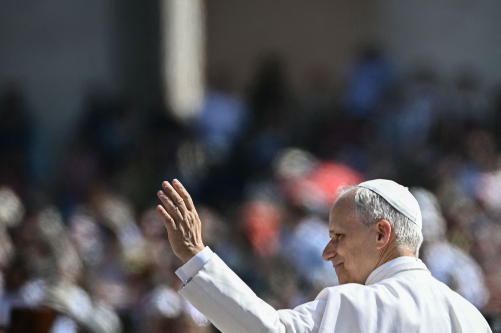 Pope Leo XIV waves to the crowd as he arrives to hold the weekly general audience in St Peter’s Square at the Vatican June 11, 2025. — AFP pic