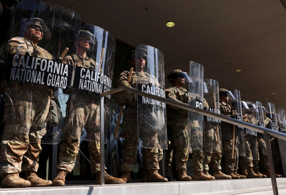 Demonstrators gather as members of the California National Guard stand guard, after their deployment by U.S. President Donald Trump, in response to protests against immigration sweeps, in Los Angeles, California June 9, 2025. — Reuters pic  