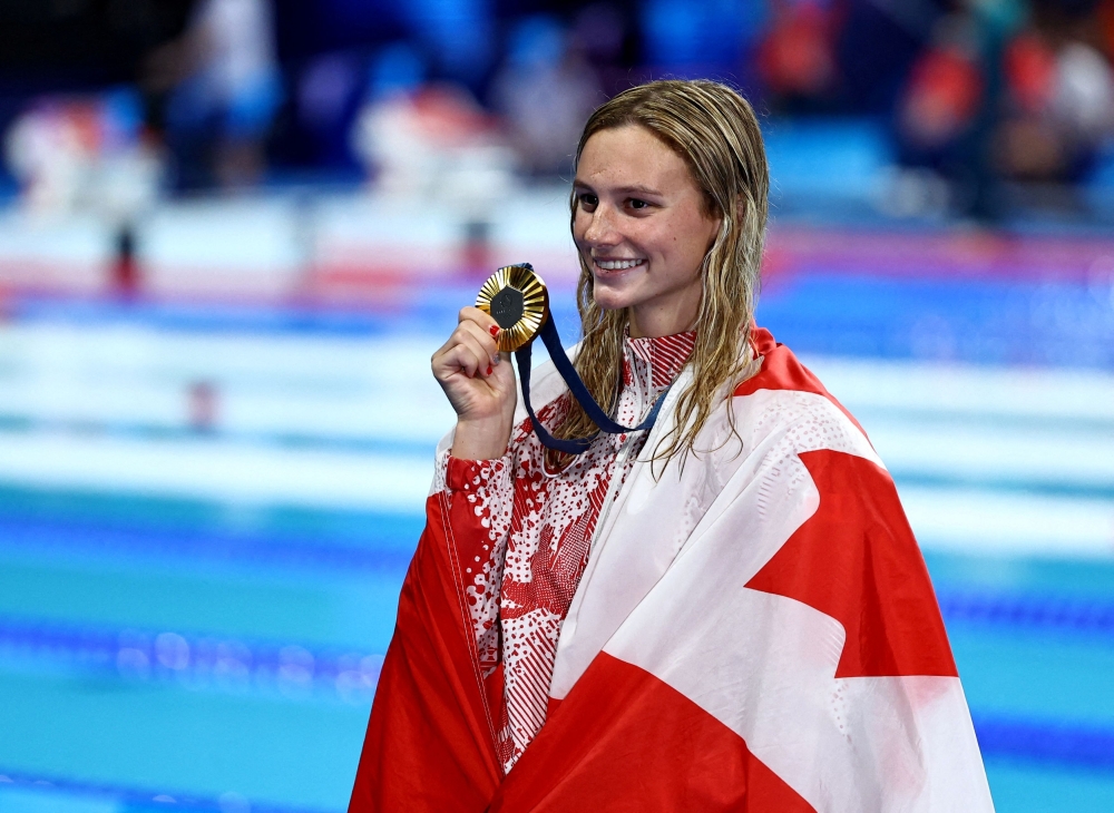 Gold medallist Summer McIntosh of Canada celebrates as she poses with her medal after winning the Paris 2024 Olympics women’s 200m individual medley at the Paris La Defence Arena, Nanterre August 3, 2024. — Reuters pic