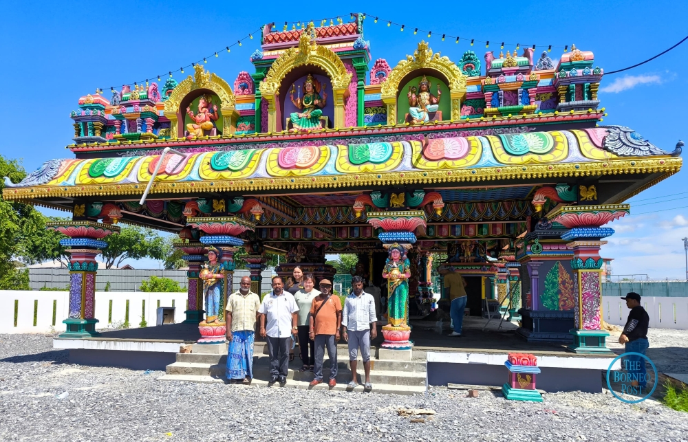 (Front from 2nd left) Manogaran and Sri Maha Mariamman Temple deputy president Vijayakumar R pose with others in front of the new temple’s main entrance. — The Borneo Post pic