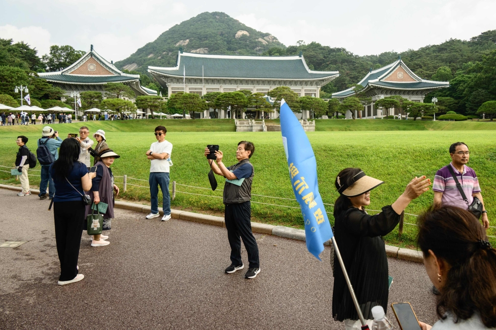 People take photos as they visit the grounds of the Blue House in Seoul on June 9, 2025, named for the approximately 150,000 hand-painted blue tiles that adorn its roof, that had been home to South Korea's leaders for seven decades until 2022, when former impeached president Yoon Suk Yeol moved out to settle in what was then the Defence Ministry headquarters, about 6 kilometres away. Tens of thousands of South Koreans poured into the Blue House in northern Seoul on June 9, as it could be their last chance to visit the premise as a new president is poised to return to the former presidential office. — AFP pic