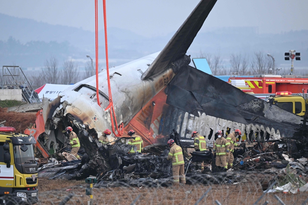 Firefighters and recovery teams work at the scene where a Jeju Air Boeing 737-800 series aircraft crashed and burst into flames at Muan International Airport in Muan, South Korea December 30, 2024. — AFP pic
