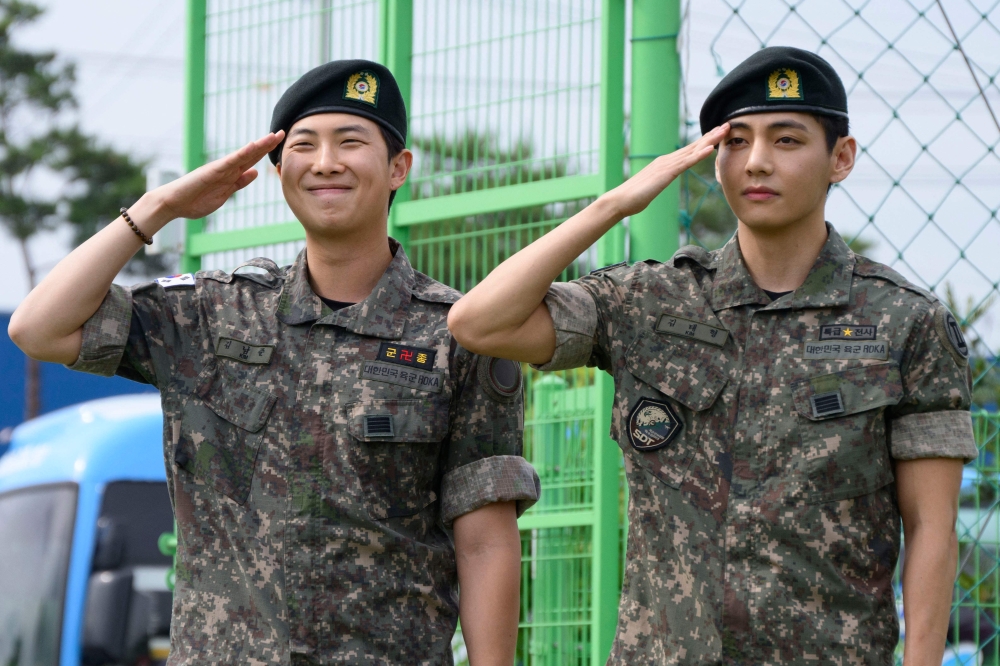 K-pop boy band BTS members RM and V salute at an outdoor sporting facility in Chuncheon June 10, 2025, after their release from 18 months of South Korean military service. — AFP pic