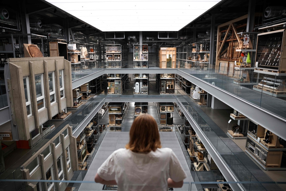 A visitor looks at the artefacts exhibited in the main room of the newly opened museum V&A East Storehouse, in East London, on June 12, 2025. London's V&A has launched a revolutionary new exhibition space, where visitors can choose from some 250,000 objects, order something they want to spend time looking at, and have it delivered to a room for a private viewing. — AFP pic