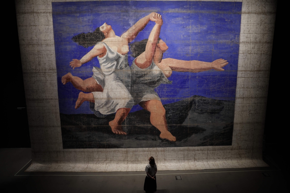 A visitor looks at the painting 