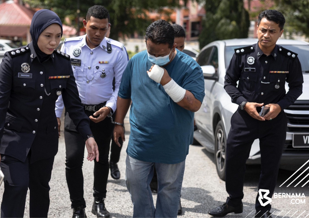 Mohd Amirul Fadhil, 39, is seen in handcuffs and under police escort at the Magistrate’s Court in Gerik, Perak on June 13, 2025 where he was charged with 15 counts of dangerous driving and a separate charge of reckless driving that killed 15 UPSI students on board the chartered bus he drove on June 9, 2025. — Bernama pic
