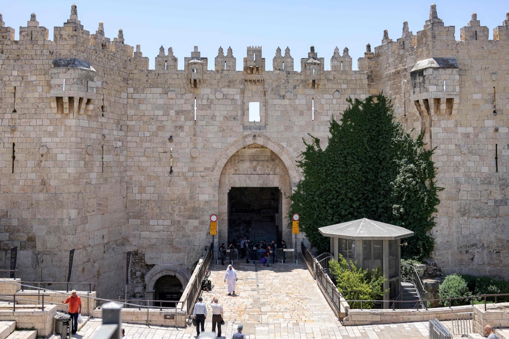 Israeli security forces stand outside the empty Damascus Gate of the old city walls of Jerusalem today. — AFP pic