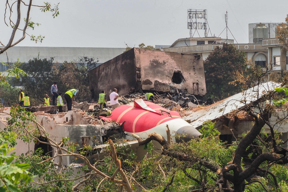 An investigation team inspects the wreckage of Air India flight 171 a day after it crashed in a residential area near the airport, in Ahmedabad on June 13, 2025. Investigators recovered a black box recorder from the crash site yesterday of a London-bound passenger jet that ploughed into a residential area of India's Ahmedabad city, killing at least 265 people on board and on the ground. — AFP pic