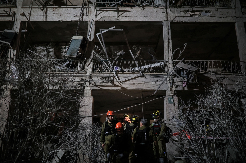 Rescue personnel work at an impact site following missile attack from Iran on Israel, in Ramat Gan June 13, 2025. — Reuters pic