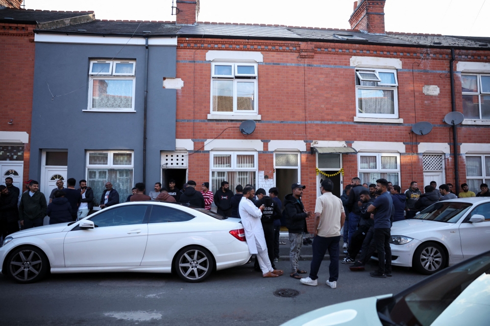 Members of local community stand outside family home of Ramesh Viswashkumar, a British survivor of the London-bound Air India aircraft crash near Ahmedabad Airport in India,  in Leicester June 12, 2025. — Reuters pic