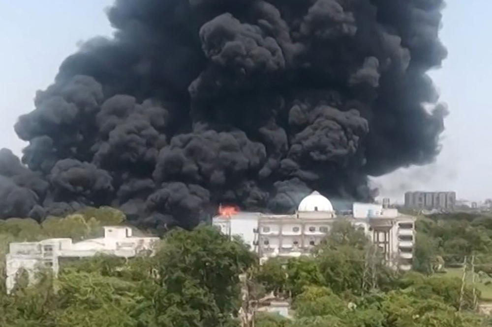 This screengrab from UGC video footage shows thick black smoke rising from a residential area after Air India flight 171 crashed in Ahmedabad on June 12, 2025. — AFP pic