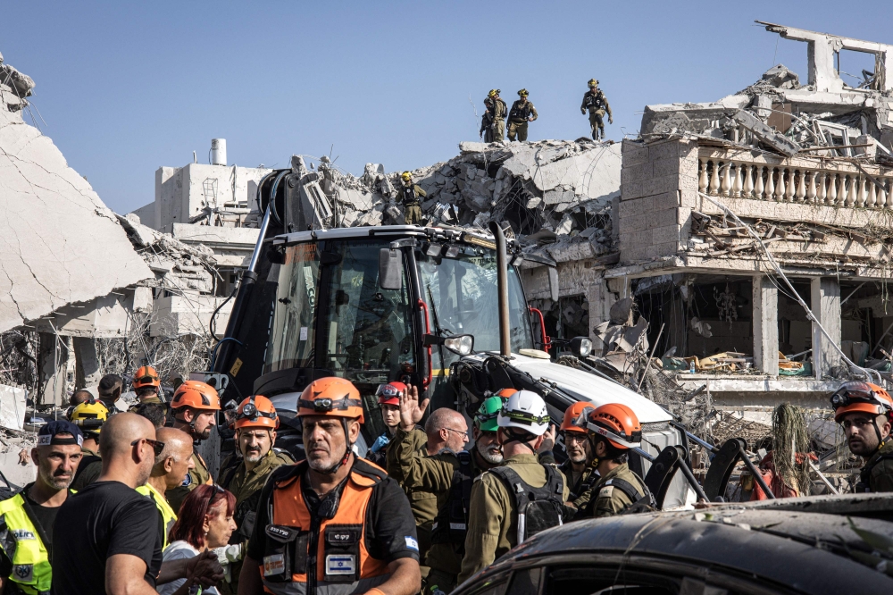 Israeli emergency responders inspect a site hit by a missile fired from Iran south of Tel Aviv on June 14, 2025. — AFP pic