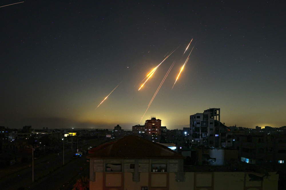 This picture taken from Nuseirat, in the central Gaza Strip, shows rocket trails in the sky late on June 13, 2025, after Iran struck Israel with barrages of missiles after a massive onslaught targeted the Islamic republic's nuclear and military facilities. 