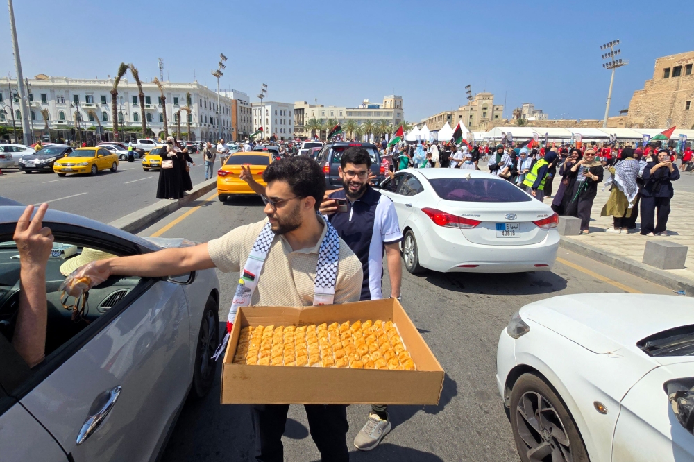 Activists, heading towards Gaza by land are greeted by Libyans after crossing into Libya from Tunisia. — AFP pic