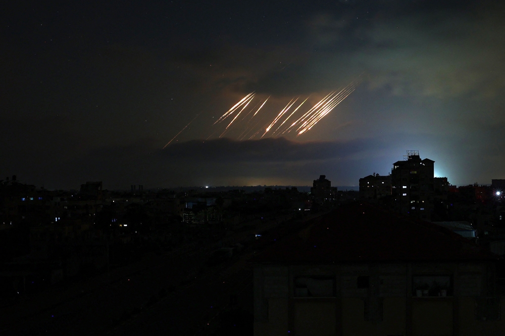 This picture taken from Nuseirat in the central Gaza Strip shows missiles fired from Iran towards Israel pictured in the night sky on June 14, 2025. — AFP pic