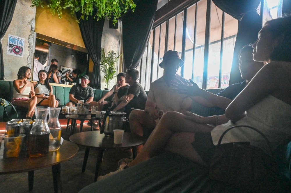 People mingle over coffee drinks at an alcohol-free clubbing event in Singapore May 24, 2025. — AFP pic