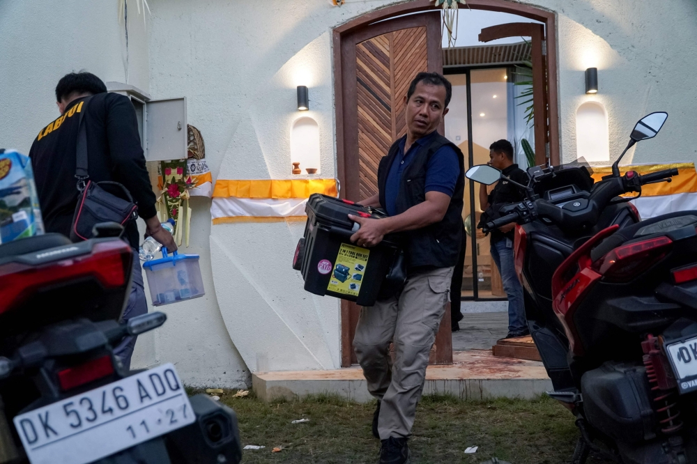 Local police officers conduct forensic examinations at the scene where two Australian nationals were shot in Munggu village, on the Indonesian resort island of Bali. — AFP pic