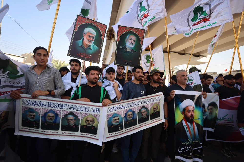 Supporters of Iraqi pro-Iran groups hold pictures of Iranian Revolutionary Guard commanders killed in the Israeli airstrikes in Tehran during a protest in Baghdad near the green zone, the ultra secured neighbourhood hosting the US embassy, on June 16, 2025, amid the Israel-Iran escalating conflict. — AFP pic 