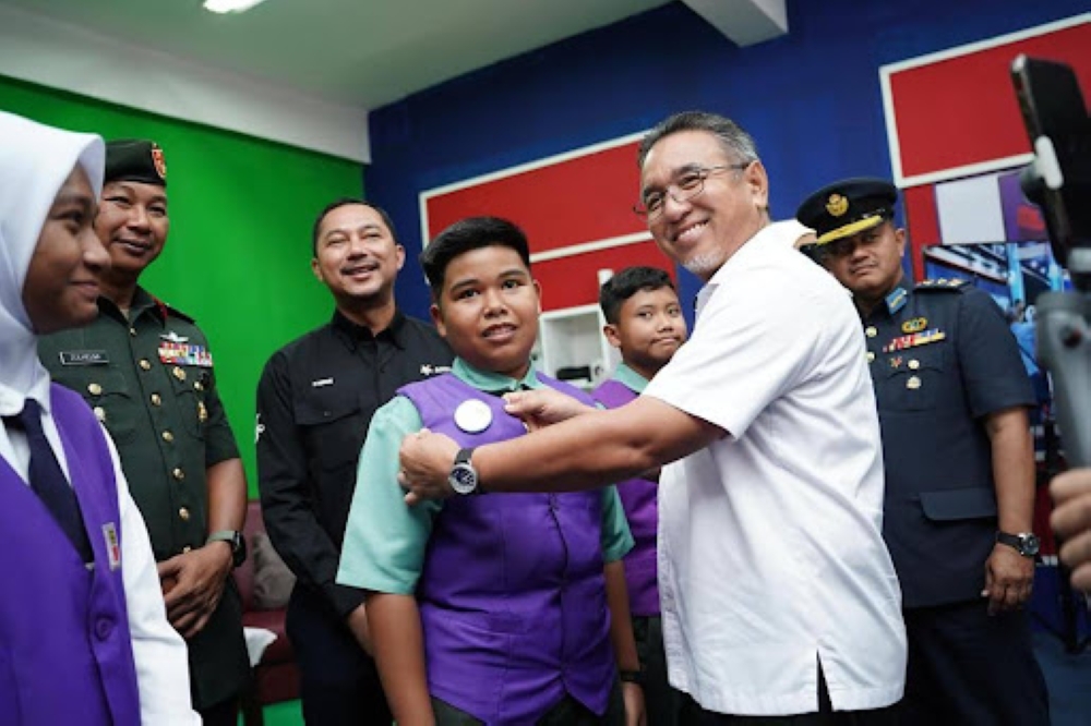 Deputy Defence Minister Adly Zahari interacting with one of the students at Sekolah Kebangsaan Sultan Sir Ibrahim.