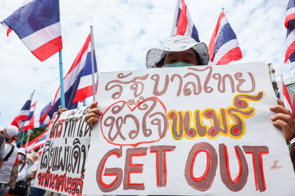 A royalist activist holds a placard that reads ‘Thai government with Khmer heart Get Out’ during an anti-government protest, following a leak on Wednesday of a phone call between Thailand’s Prime Minister Paetongtarn Shinawatra and Cambodia’s Hun Sen, the influential former premier of Cambodia, amid a border dispute between the two countries, near the Government House, in Bangkok June 19, 2025. — Reuters pic