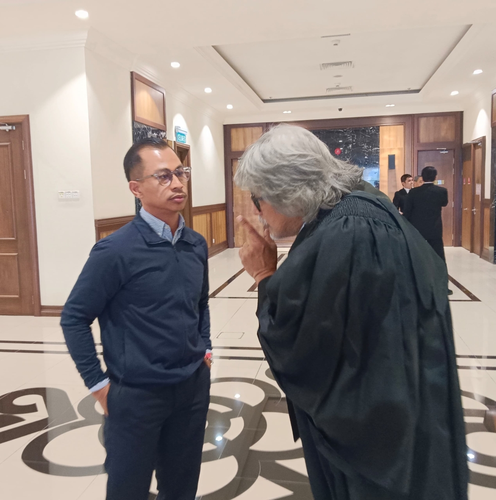 Ambree (left) at the court with his lawyer Datuk Ram Singh.