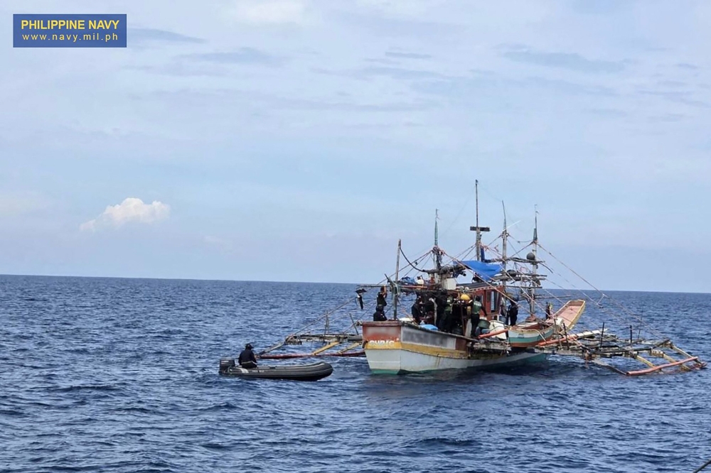This handout photo taken on June 20, 2025 and received from the Philippine Navy shows navy and law enforcement personnel searching a fishing boat after it was intercepted carrying 1.5 tonnes of illegal drugs off the coast of the main island Luzon. — Philippine Navy handout/AFP pic 