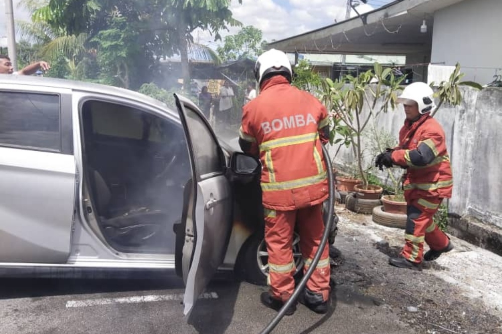 Petra Jaya firefighters extinguish the fire from on hatchback in Bandar Baru Semariang. — Picture courtesy of Fire and Rescue Department 