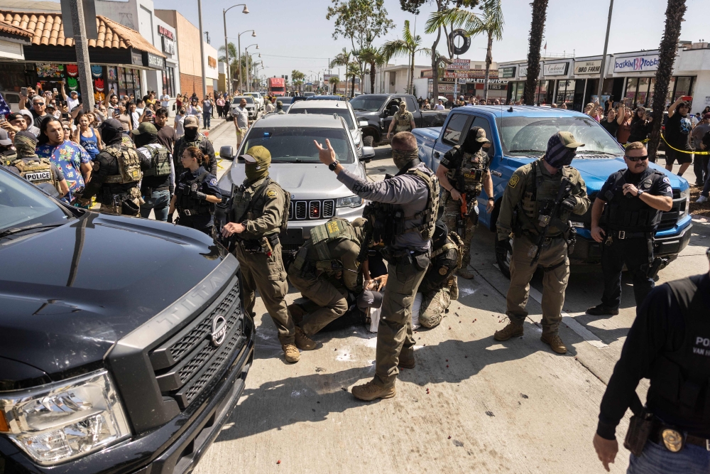 A man is detained as clashes break out after community members pushed back against a US Customs and Border Protection (CBP) attempt to raid a store in Bell, just south of Los Angeles, California, on June 20, 2025. — AFP pic