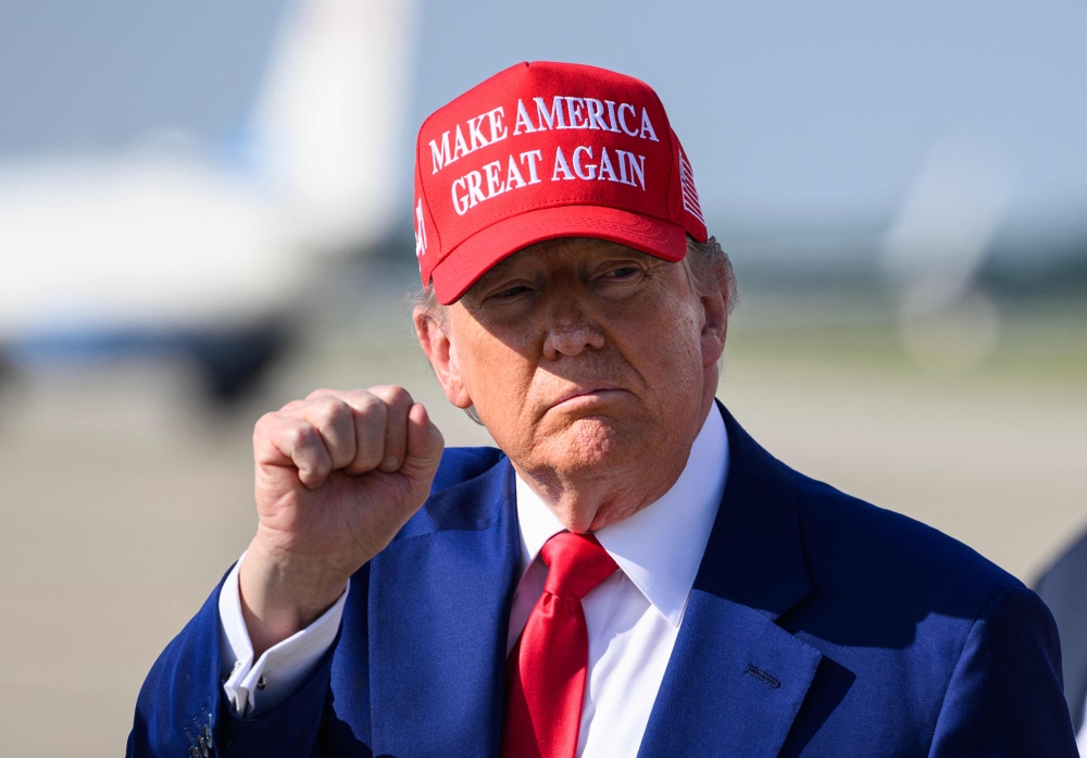 US President Donald Trump gestures towards reporters after steping off Air Force One upon return to Joint Base Andrews in Maryland June 22, 2025. — AFP pic