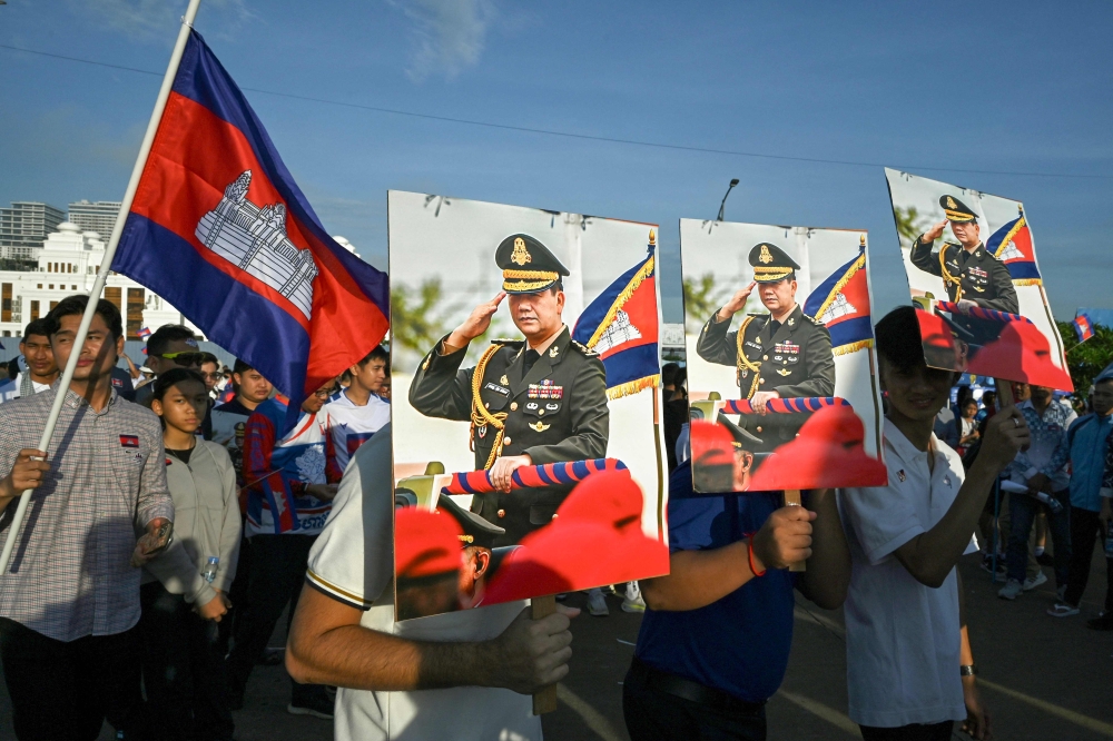 People hold portraits of Prime Minister Hun Manet as they take part in a solidarity march organised in support of the Cambodian government’s actions in its recent border dispute with Thailand, in Phnom Penh on June 18, 2025. — AFP pic 