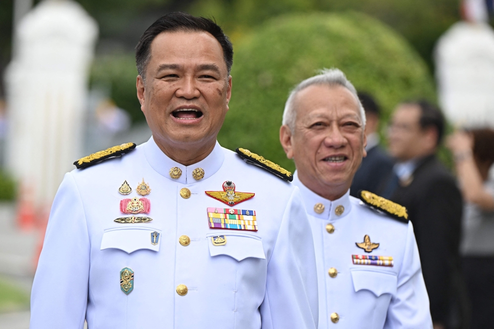 Thailand's Deputy Prime Minister, Interior Minister and Bhumjaithai Party leader Anutin Charnvirakul (left) is seen with labour minister and Bhumjaithai Party member Phiphat Ratchakitprakarn (right). — AFP pic