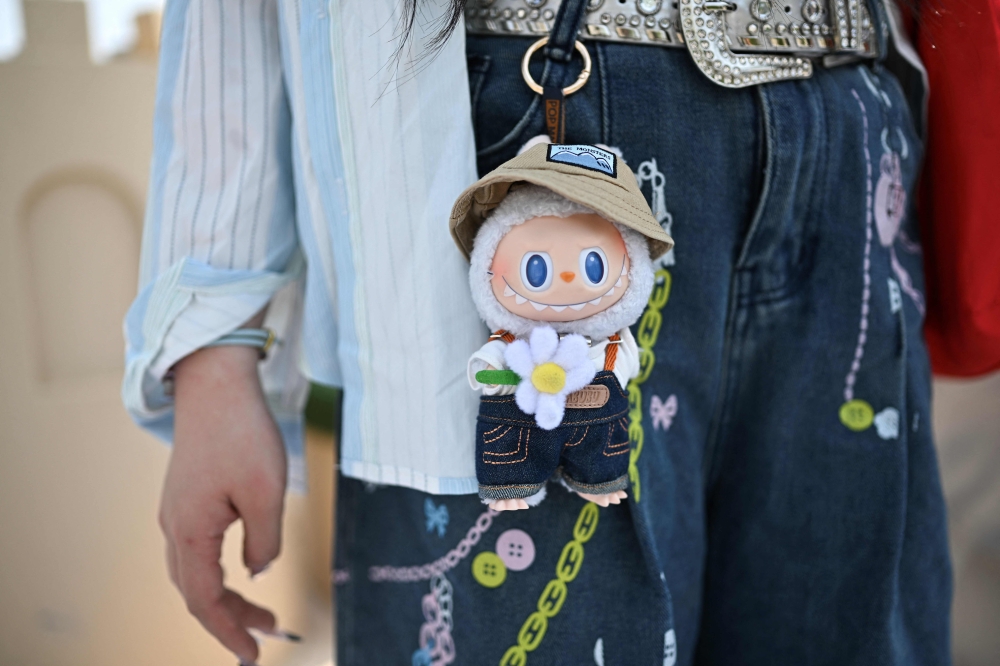 This picture taken on June 18, 2025 shows a woman with a figure of the character Labubu as she visits Pop Mart’s theme park Pop Land in Beijing. — AFP pic 