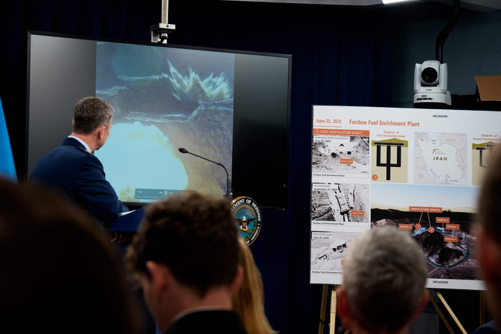 Chairman of the Joint Chiefs of Staff Air Force Gen Dan Caine turns to watch a video of a bombing test of the GBU-57A/B Massive Ordnance Penetrator (MOP) used in the attack on the Iranian Fordow Fuel Enrichment Plant during a news conference with US Defense Secretary Pete Hegseth at the Pentagon on June 26, 2025 in Arlington, Virginia. — Andrew Harnik/Getty Images pic via AFP 