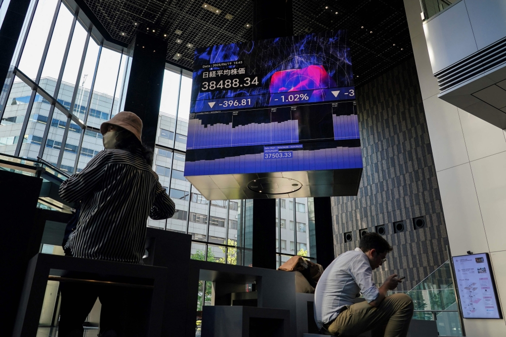An electronic board (top) shows the closing numbers of the Nikkei Stock Average on the Tokyo Stock Exchange in Tokyo on June 19, 2025. The Nikkei jumped 1.5 per cent and surpassed the 40,000 mark for the first time in five months. — AFP pic 