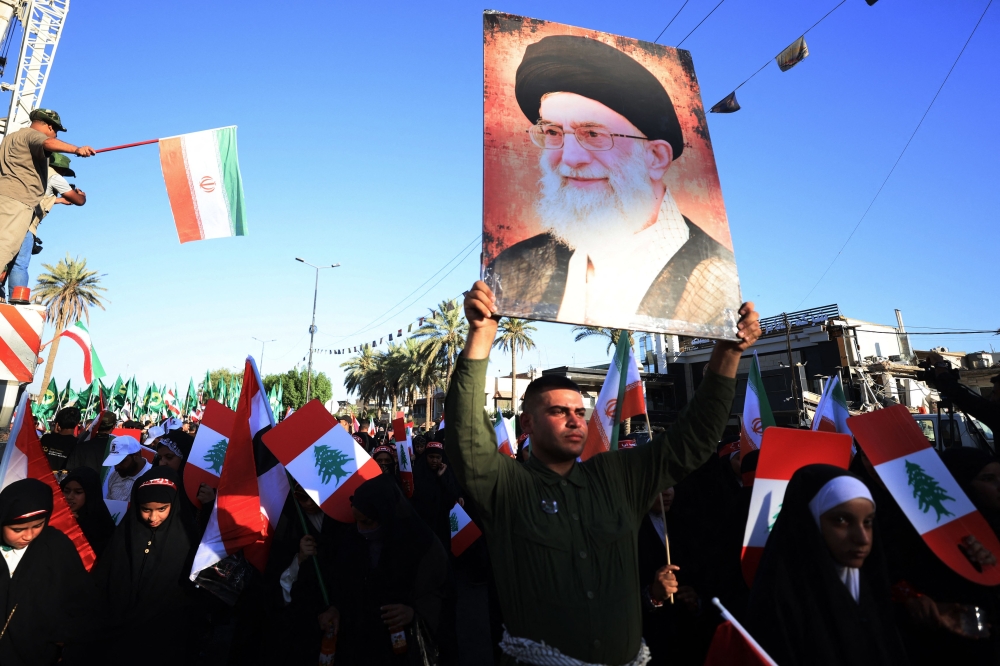 Iraqis wave a portrait of Iran's supreme leader Ayatollah Ali Khamenei as they march in the Kadhimiya district of Baghdad on June 21, 2025, to protest against Israel's strikes on Iran. — AFP pic