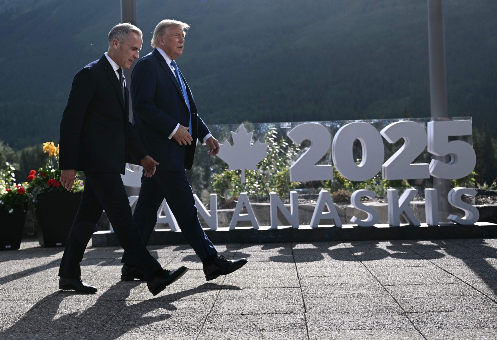 Canadian Prime Minister Mark Carney and US President Donald Trump arrive for a family photo during the Group of Seven (G7) Summit at the Kananaskis Country Golf Course in Kananaskis, Alberta, Canada, on June 16, 2025. — AFP pic