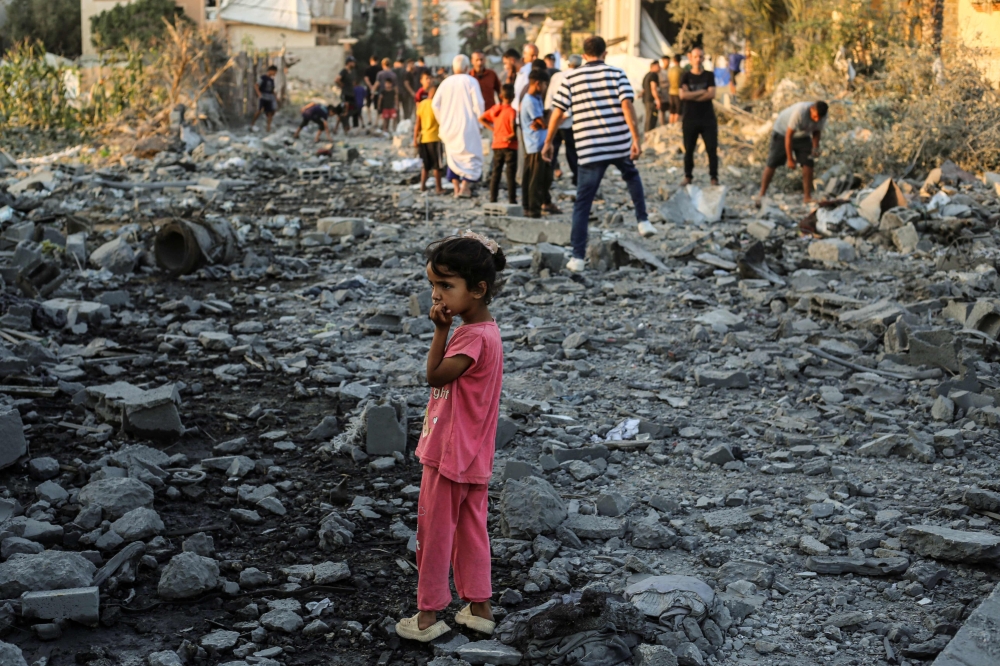 A Palestinian girl stands on rubble as she looks at the destruction in the Al-Bureij camp in the central Gaza Strip after a house was targeted by an Israeli strike, on June 27, 2025. — AFP pic