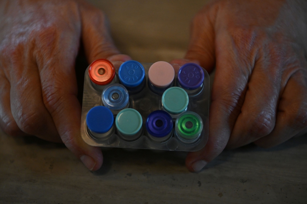Amy Spencer holds a number of vials containing components of obesity drugs, which were purchased through the grey market, a new market for obesity drugs that allows consumers to purchase medication materials from China and reconstitute them into injectable drugs, at her home in southern Missouri April 24, 2025. — Reuters pic