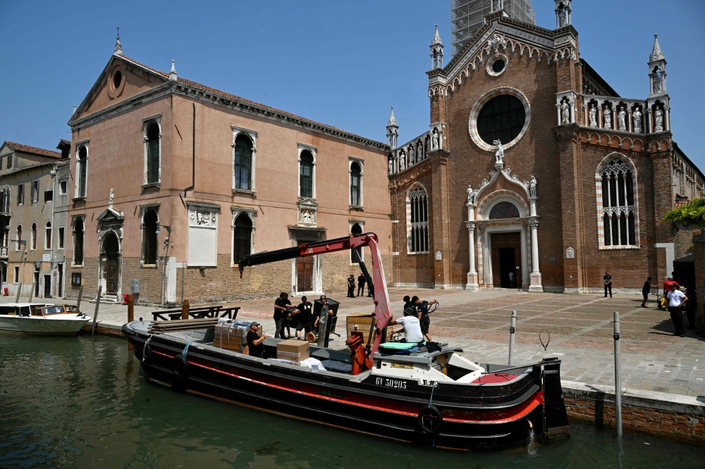 Workers unload a barge in front of the Madonna dell'Orto church in Venice on June 25, 2025. Celebrities in superyachts sail into Venice this week for the three-day wedding party of Amazon tycoon Jeff Bezos and Lauren Sanchez, despite irate locals who say the Unesco city is no billionaire's playground. — AFP pic  