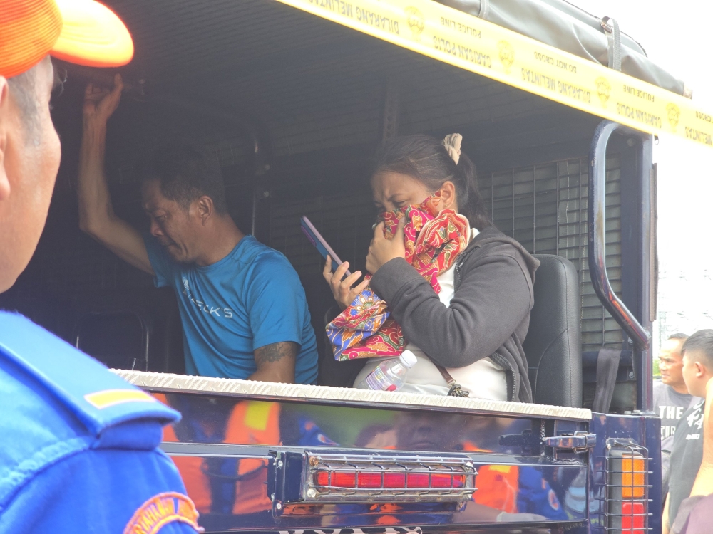 Family members of the deceased being transported along with the victim’s body to help with the identification process. — The Borneo Post pic