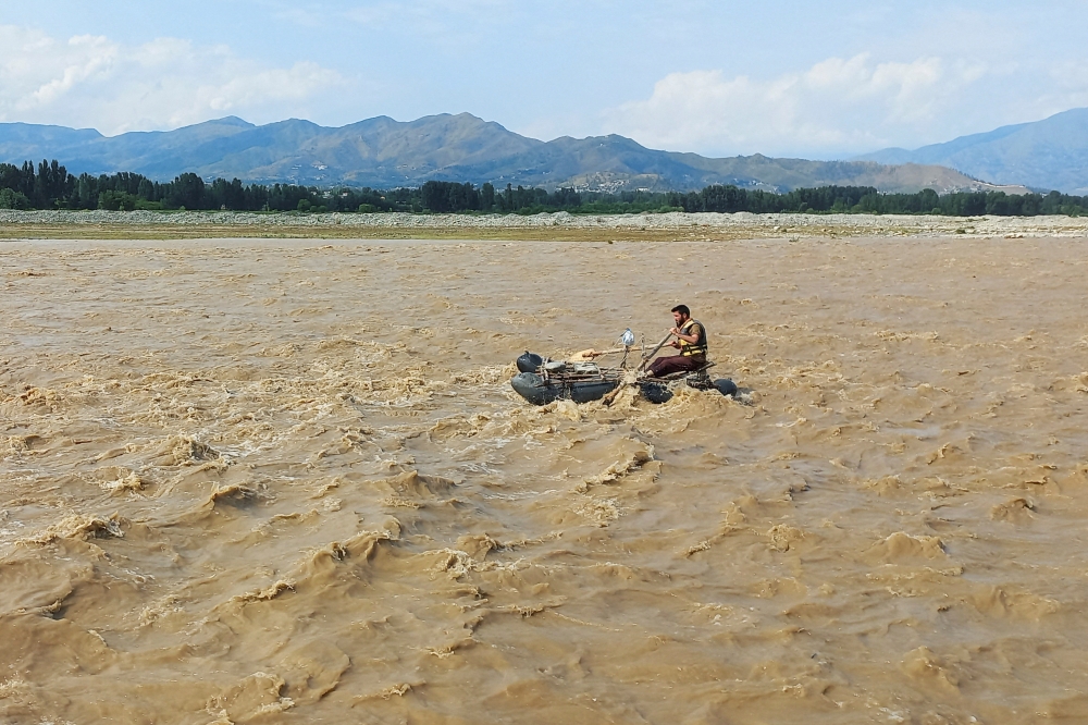 A rescue worker rows a raft while searching for survivors, after tourists, who were on a picnic, were swept away by overflowing floodwaters in the Swat River, in Swat Valley in Pakistan June 27, 2025. — Reuters pic 