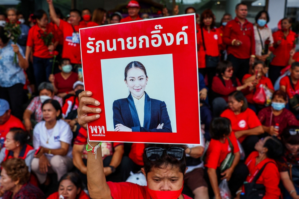 A Pheu Thai supporter holds a placard with a portrait of Thailand’s Prime Minister Paetongtarn Shinawatra as people gather at Pheu Thai Party Headquarter to support Paetongtarn, as she battles to stay in power after drawing sharp criticism of her handling of a border row with Cambodia, in Bangkok June 27, 2025. — Reuters pic