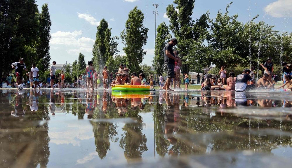 People cool off underneath water fountains in the Madrid Rio recreation area during the first heatwave of the summer in Madrid, on June 28, 2025. — AFP pic
