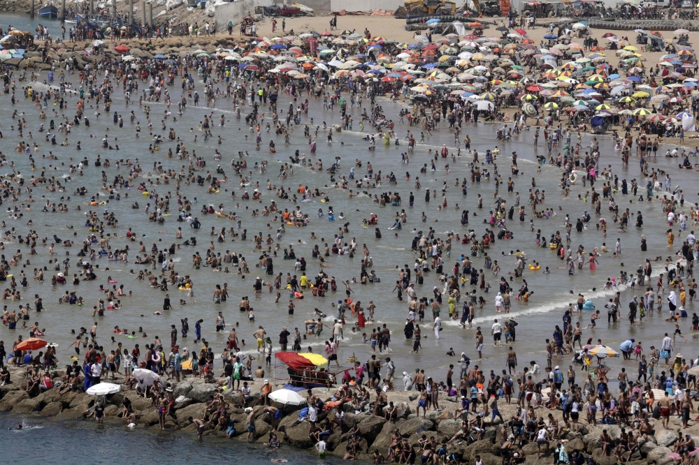 People cool off at a beach during a heatwave in Rabat. Monthly temperature records have been broken across Morocco, sometimes topping seasonal norms by as much as 20 degrees Celsius. — AFP pic
