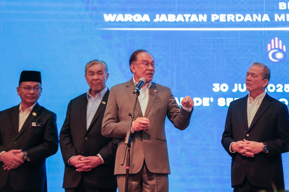 Prime Minister Datuk Seri Anwar Ibrahim (second from right) speaks at the monthly assembly of personnel in the Prime Minister’s Office in Putrajaya on June 30, 2025 — Picture by Raymond Manuel