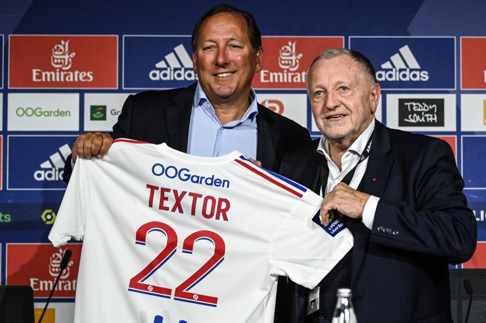Lyon football club president Jean-Michel Aulas and US businessman John Textor (left) pose at the end of a press conference to announce the sell of a major stake of the club to Textor's Eagle Football Holdings, in Decines-Charpieu, near Lyon, on June 21, 2022. — AFP pic