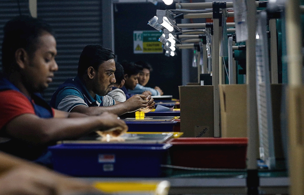 Factory workers assemble a lighting apparatus during a site visit to a plant in Juru, Penang, February 11, 2020. — Picture by Sayuti Zainudin
